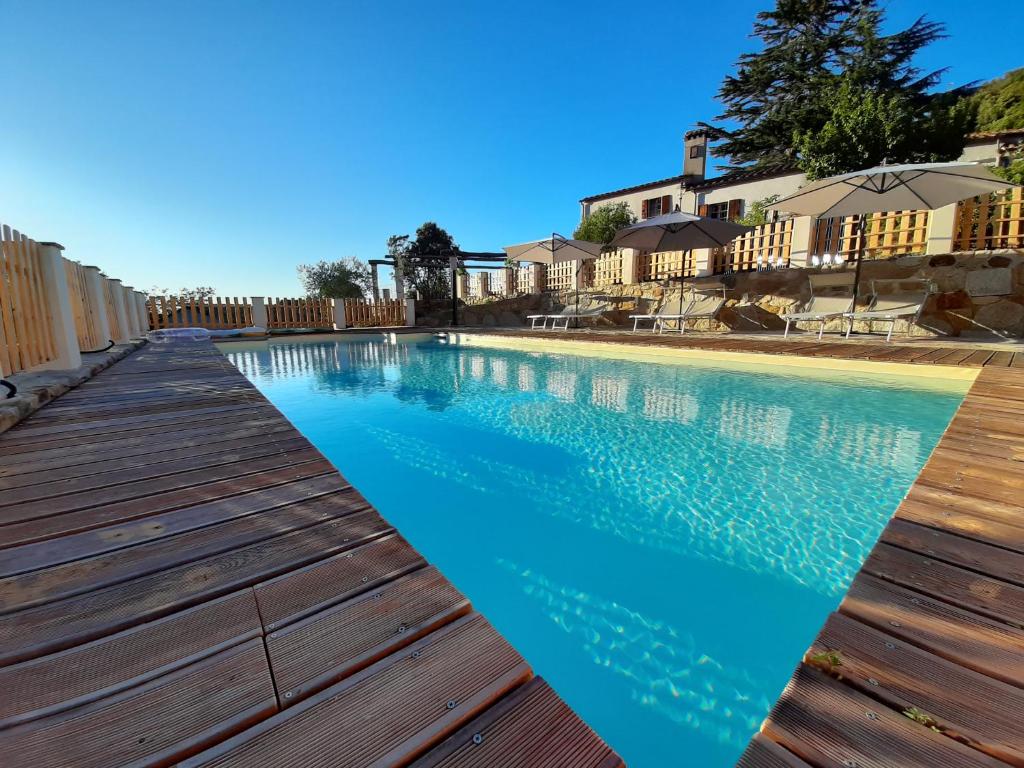 马尔恰纳Fonte di Zeno的一个带木甲板和蓝色海水的游泳池