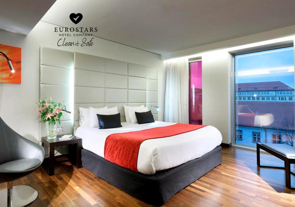 慕尼黑欧洲之星大中心酒店的一间卧室设有一张大床和一个大窗户