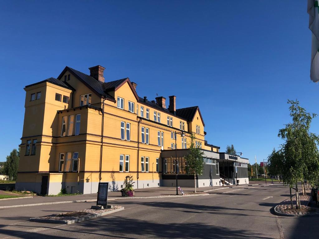 奥萨Orsa Järnvägshotell的街道边的黄色大建筑