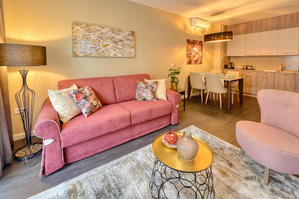 萨尔瓦尔Club Luxury Apartman的一间带粉色沙发的客厅和一间厨房
