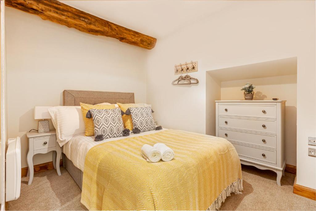 赫里福德Guest Homes - The Merchant House Apartments的一间卧室配有一张带黄毯的床和梳妆台
