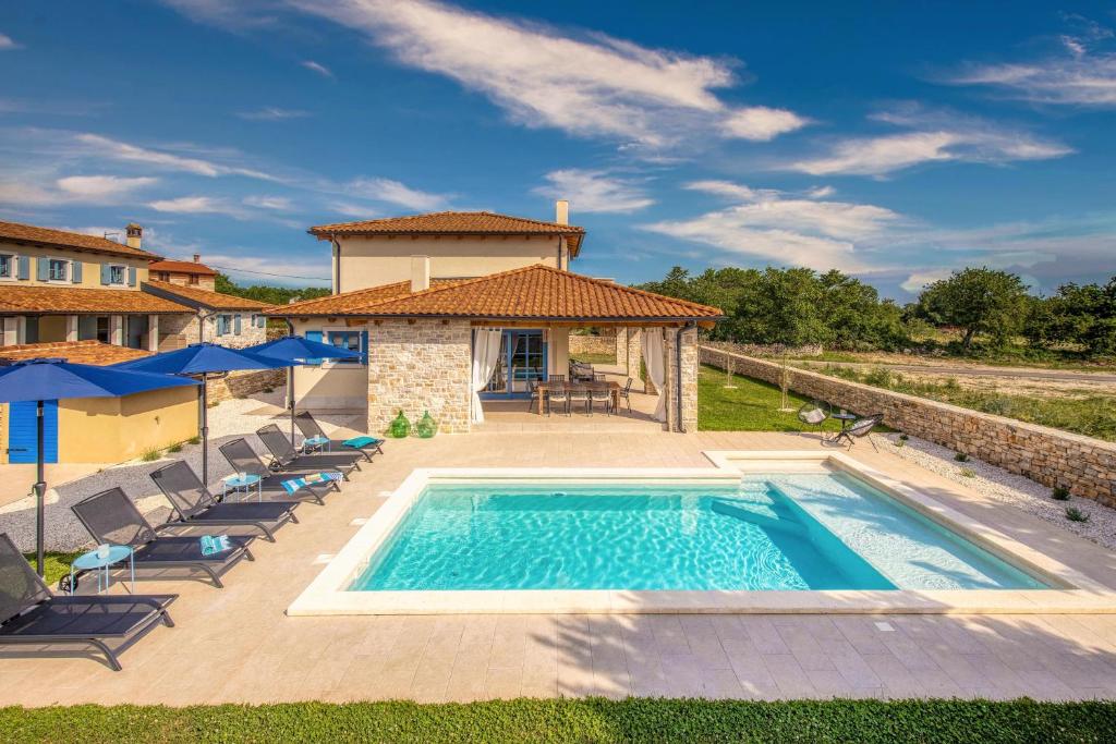 罗维尼Villa Aria Istria的一座带游泳池和房子的别墅