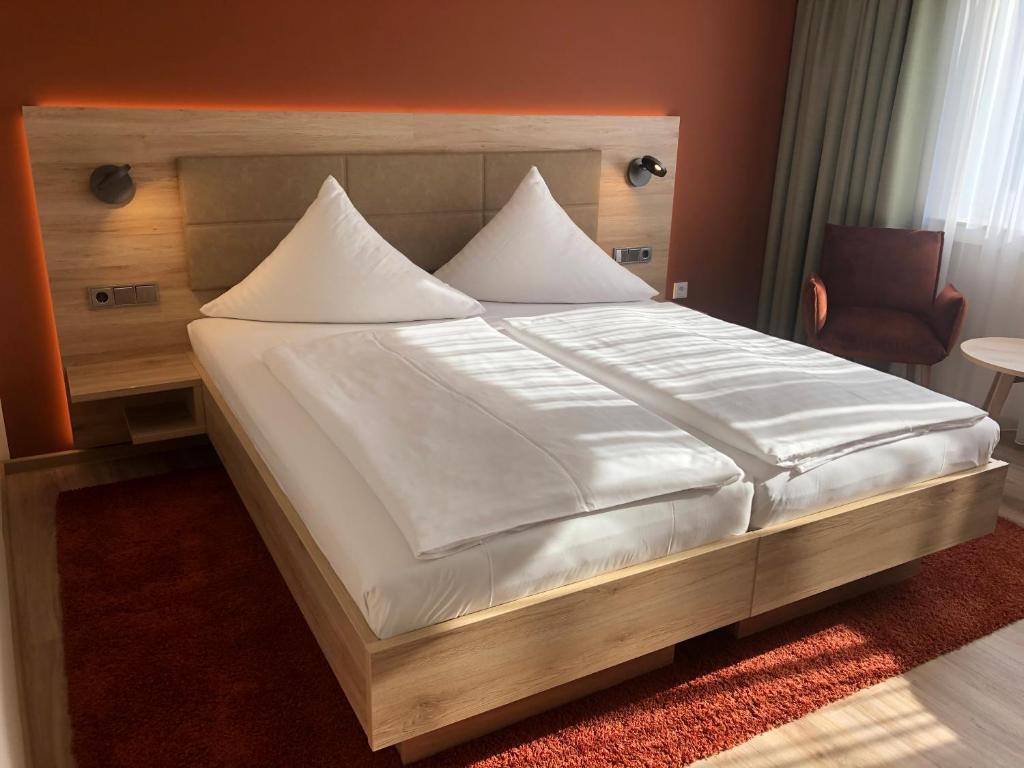 科隆Hotel Wilms的一间卧室配有一张带白色床单的大床