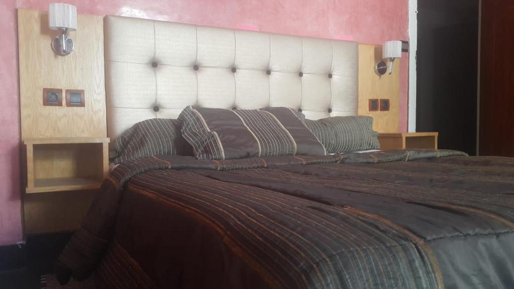 拉巴特HOTEL VELLEDA的一间卧室配有一张大床和大床头板