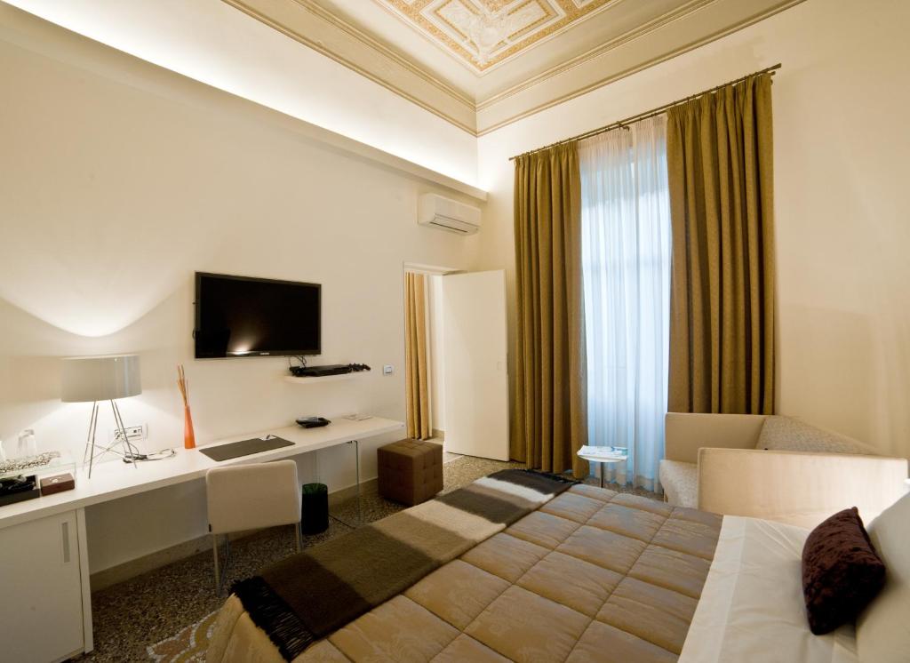 雷焦卡拉布里亚城镇之屋凯沃尔酒店的酒店客房配有一张床、一张书桌和一台电视。