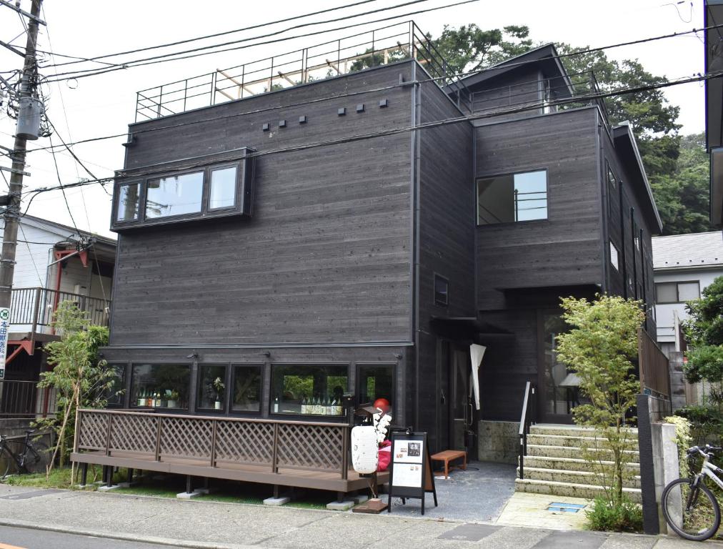 镰仓市B&B KAMAKURA的前面有长凳的黑房子
