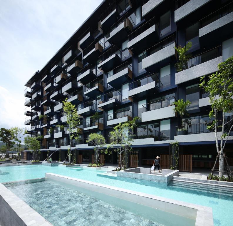 华欣Seamira House Huahin - SHA的公寓大楼前方设有游泳池