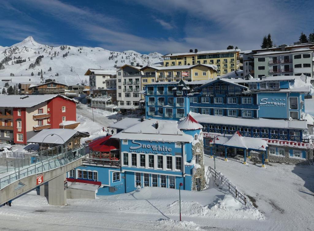 上陶恩白雪运动酒店的一座有雪盖建筑和山的城镇