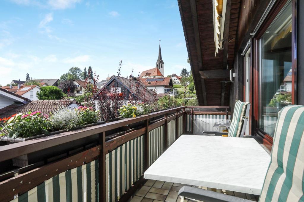 HergensweilerFerienwohnung Irmi的阳台配有桌椅和鲜花。