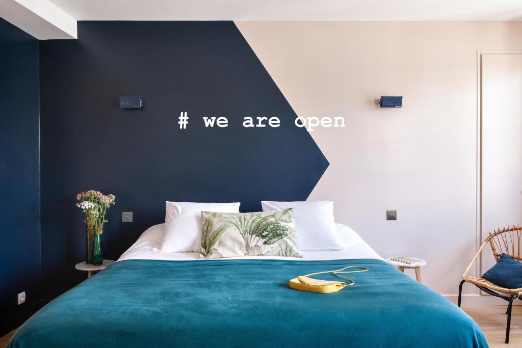 巴黎亨丽埃特酒店的一间卧室配有一张蓝色的床,上面有香蕉