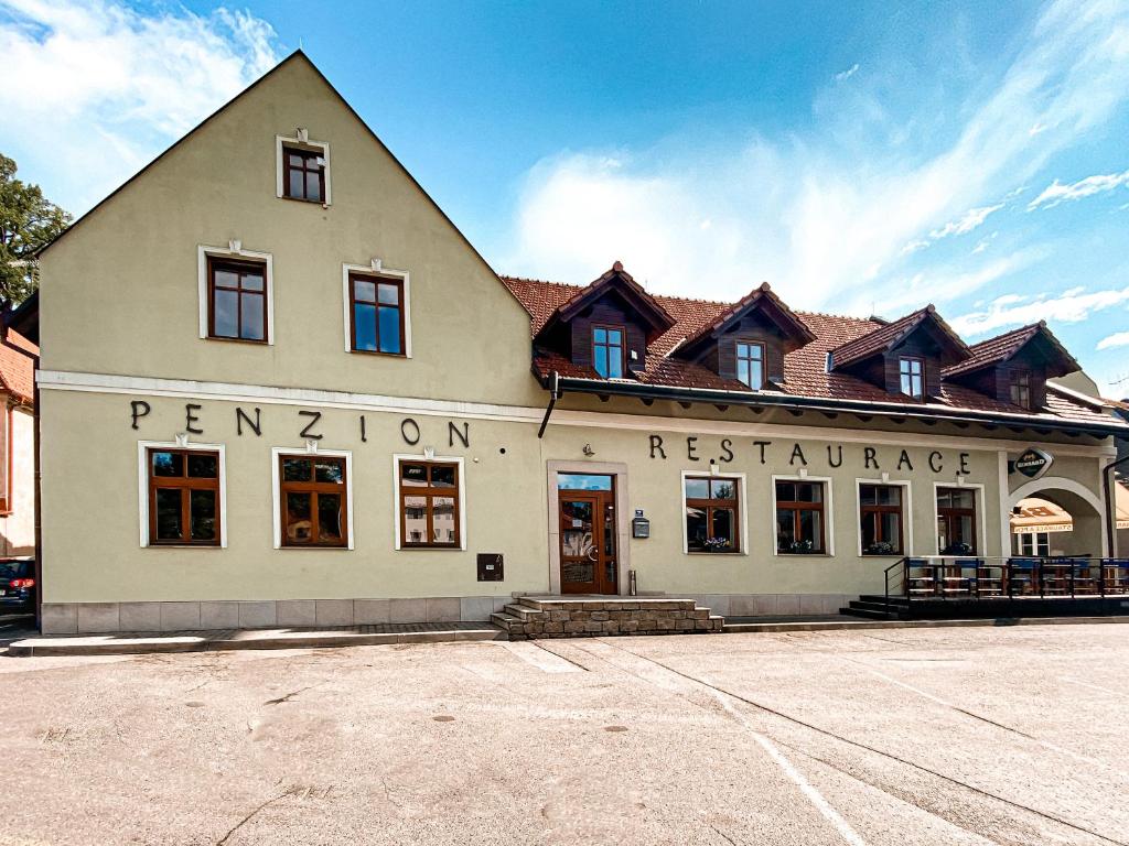 萨扎瓦河畔莱代奇Penzion a restaurace U ŘEKY的白色的建筑,有屋顶