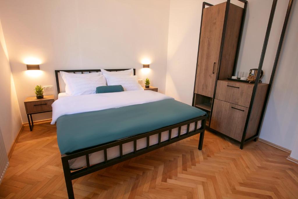 普里什蒂纳Grand Boutique Hotel的一间卧室设有一张大床,铺有木地板