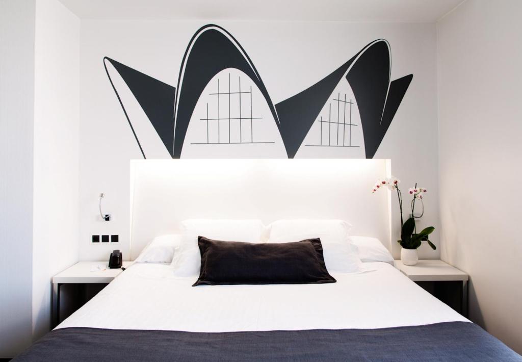 瓦伦西亚迪玛尔酒店的一间卧室配有一张带黑白床头板的床