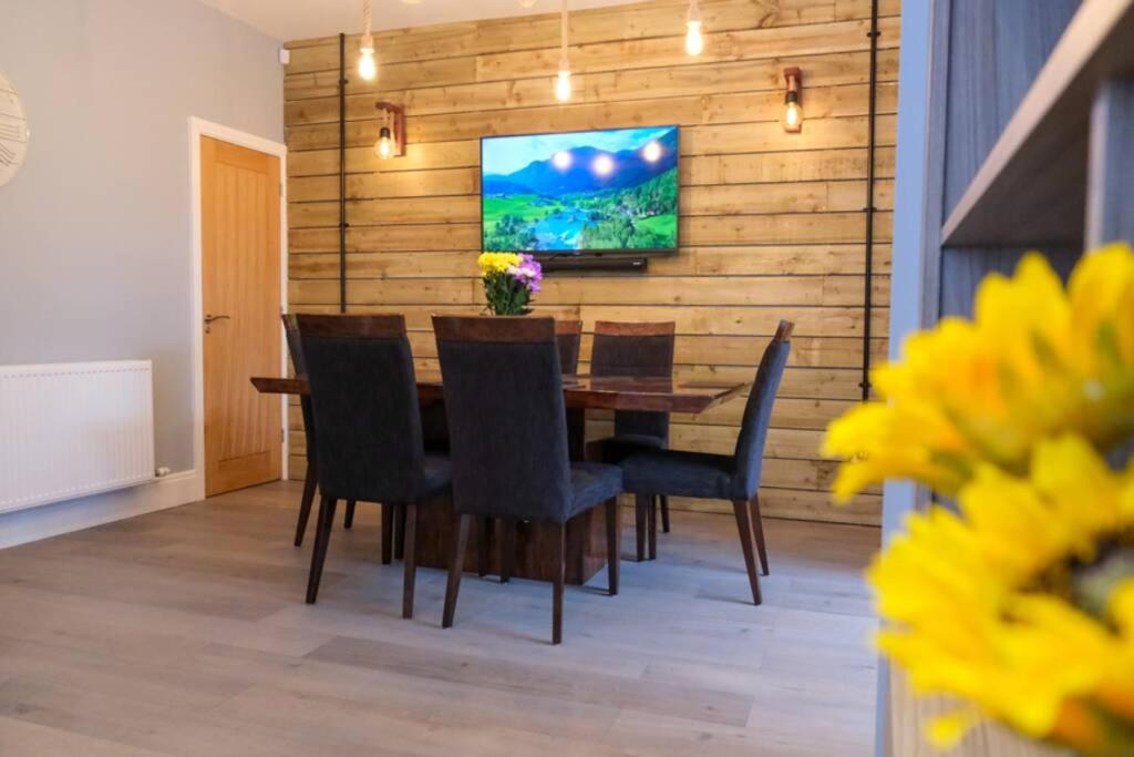 布莱克浦Westcliffe House的用餐室设有木墙,配有桌椅