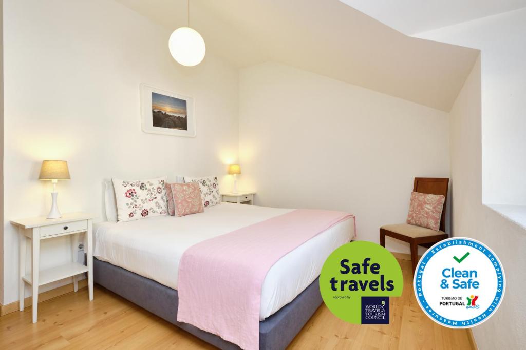 辛特拉辛特拉布利斯阿帕尔特公寓的一间卧室配有一张带粉色毯子的床