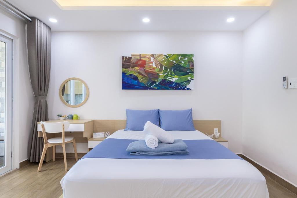 胡志明市Cozrum Homes - Yoga Corner的一间卧室配有一张大床和一张书桌