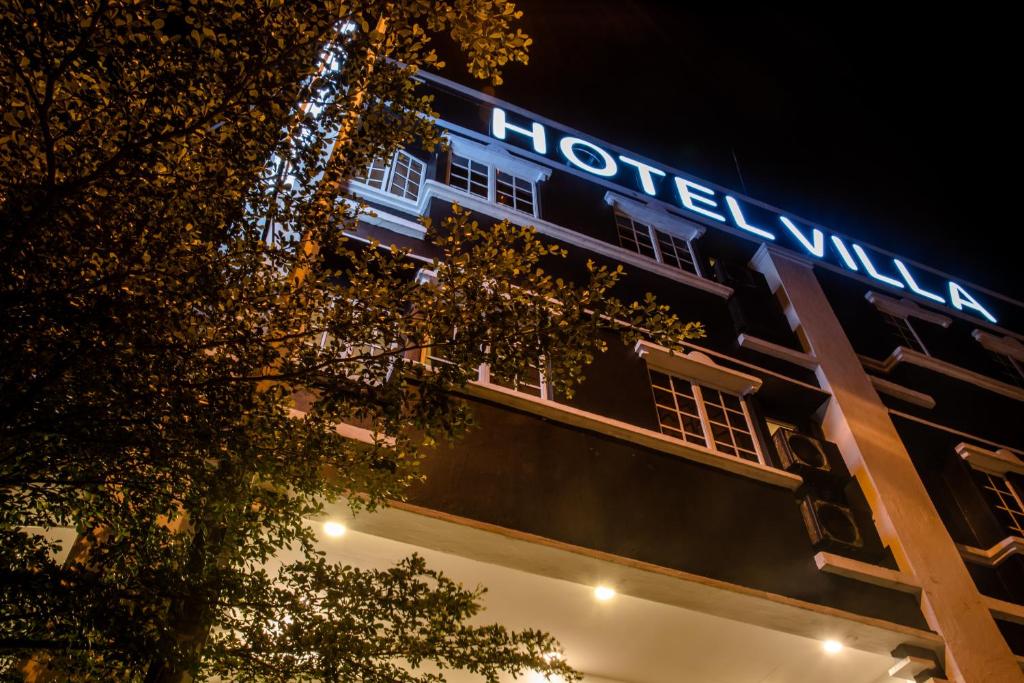 芙蓉Hotel Villa的夜间有酒店标志的建筑