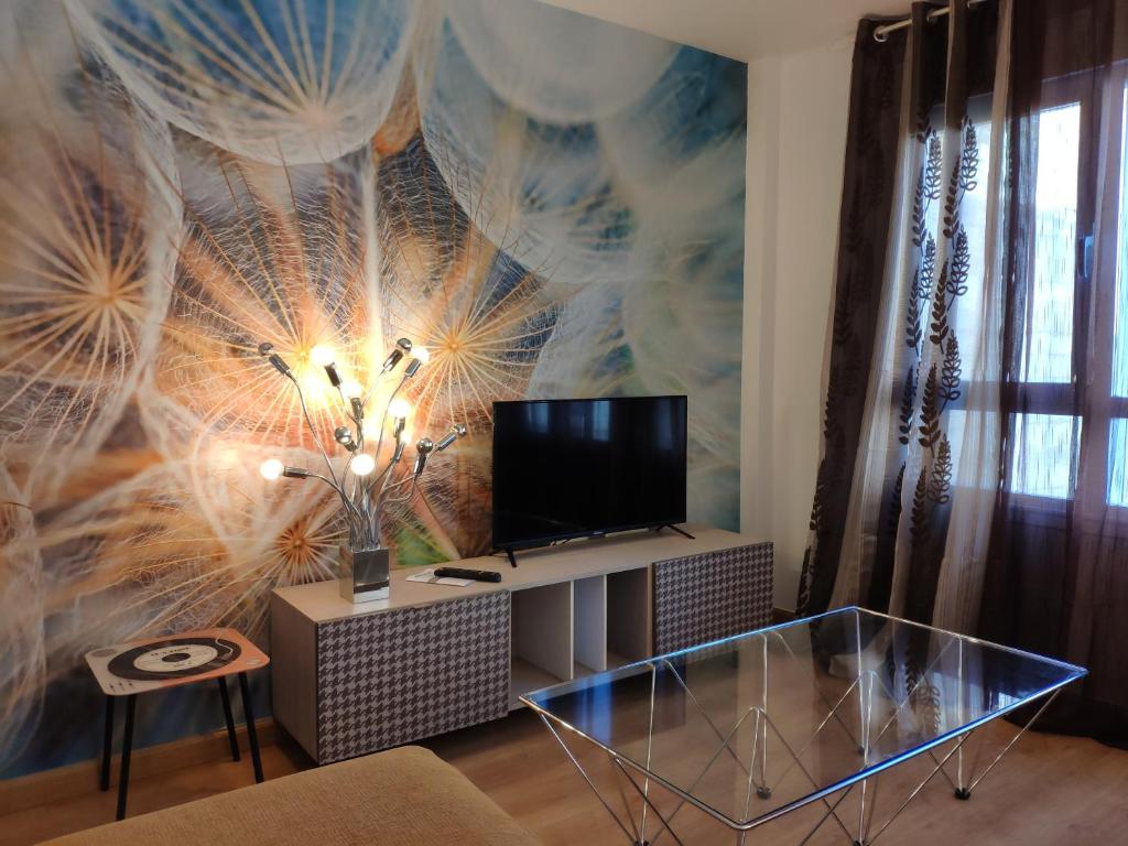 LumpiaqueCasa las Nubes的一间带电视和玻璃桌的客厅