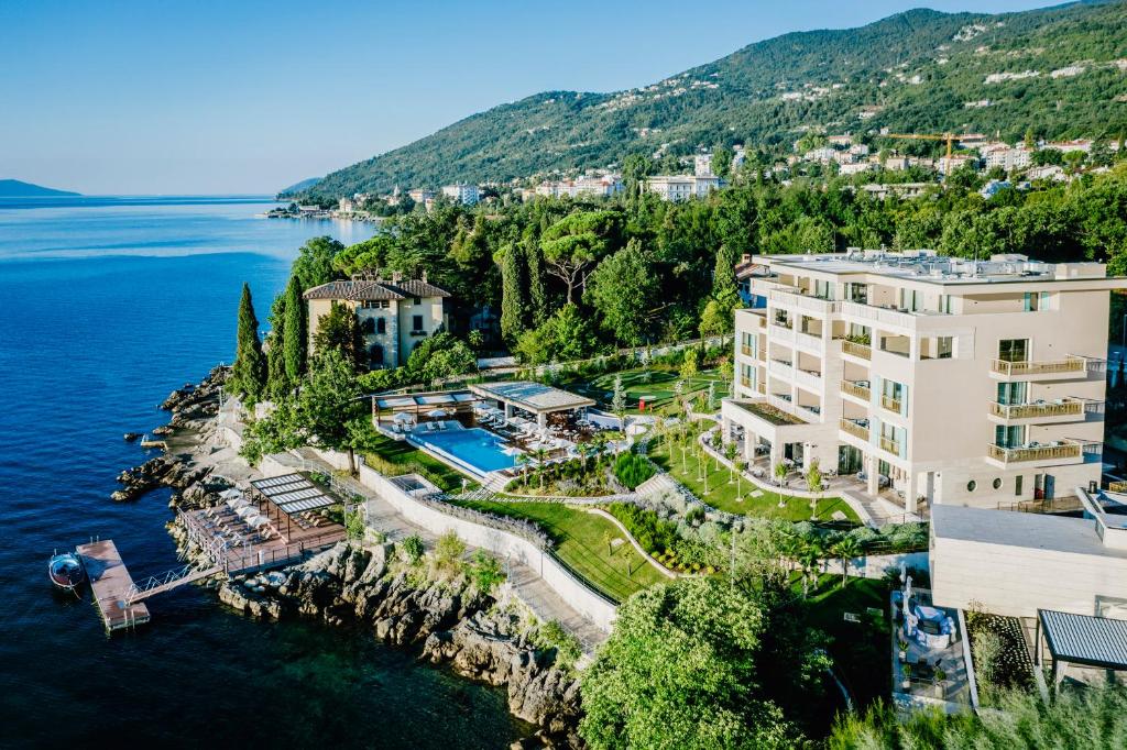奥帕提亚Ikador Luxury Boutique Hotel & Spa的水边悬崖上建筑物的空中景观
