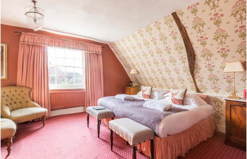亨利昂泰晤士汗布尔登雄鹿与猎人旅馆的一间卧室设有一张大床和一个窗户。