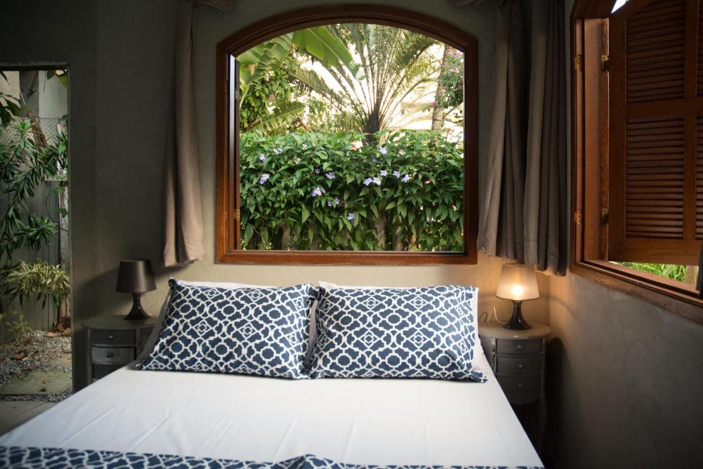 布希奥斯Jardim Secreto Guest House的一间卧室配有一张带窗户的床