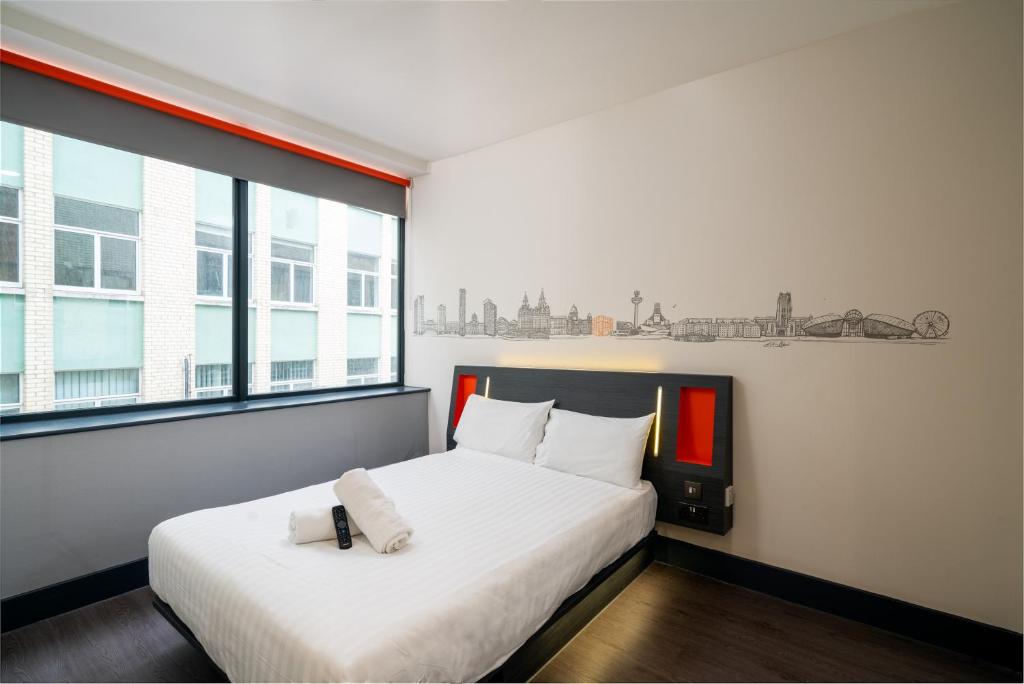 利物浦利物浦便捷酒店的一间卧室配有一张带白色床单的床和一扇窗户。