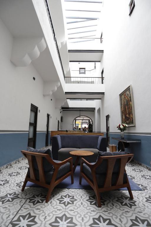 普埃布拉Hotel Sofia的大堂配有沙发、椅子和桌子