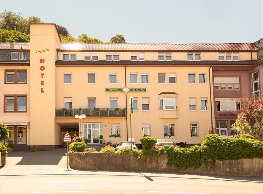 兰施图尔阿瓦隆酒店的一座棕褐色的建筑,前面有标志
