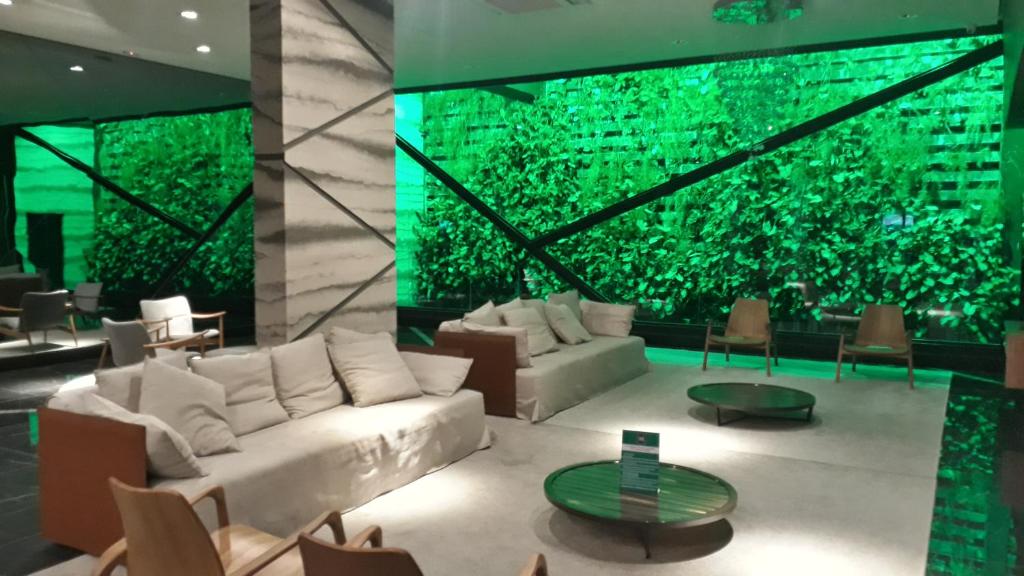马塞约Time Home Service 1411的客厅设有白色沙发和绿色墙壁。