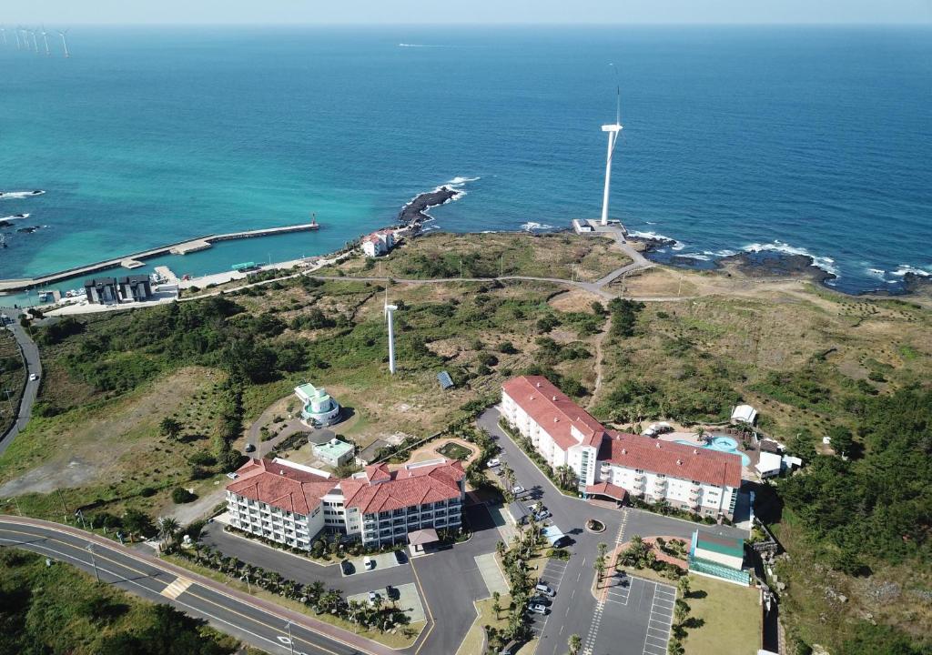 济州市蓝色夏威夷酒店的靠近大海的山丘上风力涡轮机的空中景观