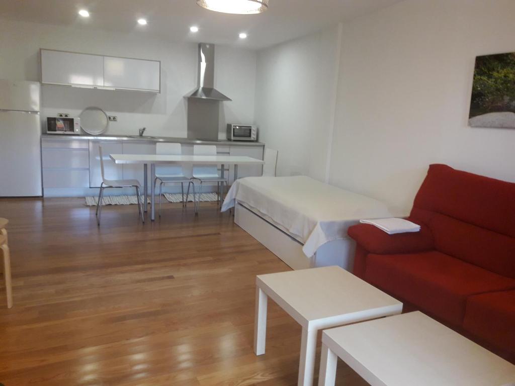 哈赖斯德拉韦拉Apartamentos y Estudios LA RISTRA的一间带红色沙发的客厅和一间厨房