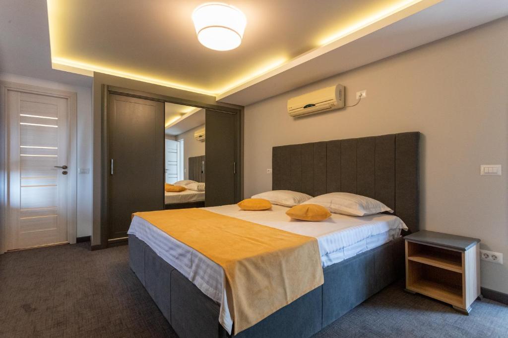福克沙尼Corso Apartments B&B的一间卧室配有一张带橙色枕头的大床