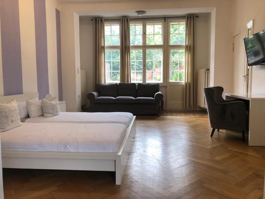 柏林柏林伊拉公寓酒店的一间卧室配有一张床、一张沙发和一台钢琴
