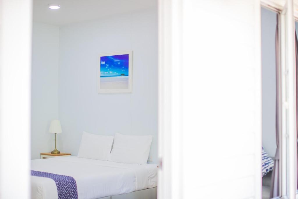 帕克蒙蓝色岸边度假屋的白色的卧室设有床和窗户
