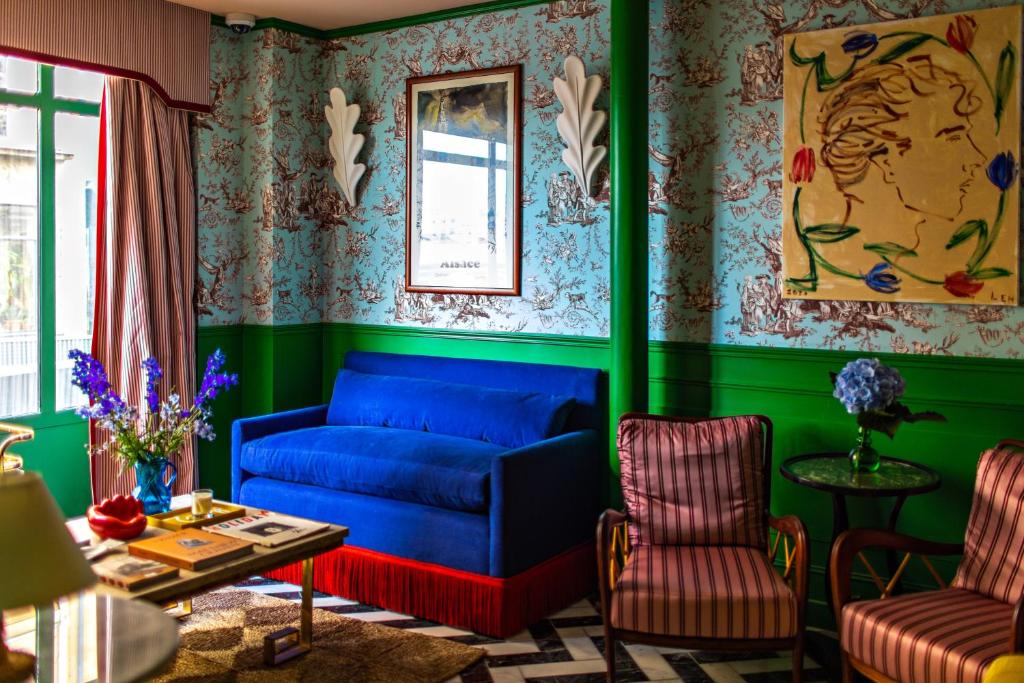 巴黎Hôtel Les Deux Gares的客厅设有蓝色的沙发和绿色的墙壁。