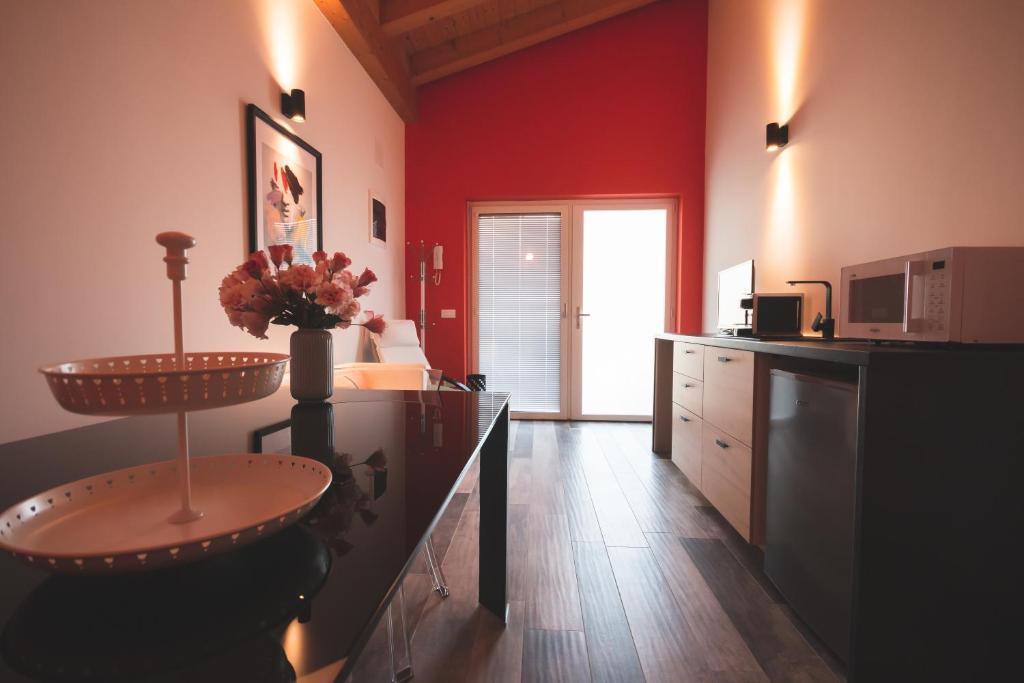 龙基德伊莱焦纳里B&B OASI的厨房设有红色的墙壁和带水槽的台面
