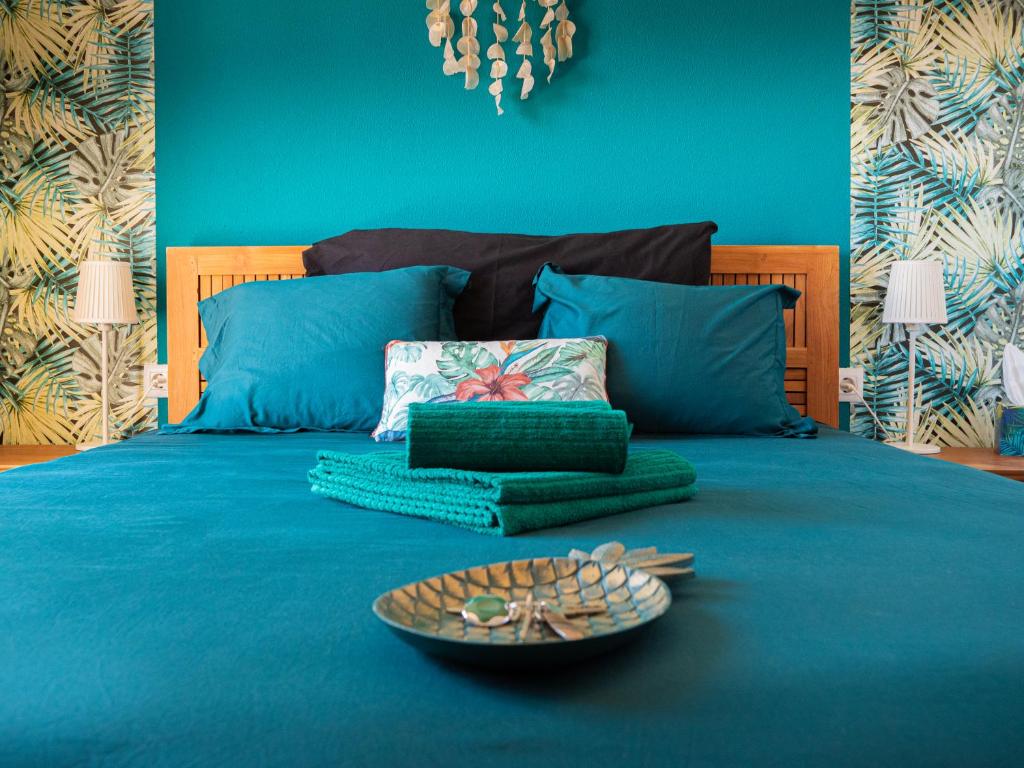 塔里法Akiteness House Tarifa的一张蓝色的床,上面有一盘食物