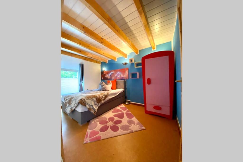 KallOldschool, Dorfschule mit Whirlpool的一间卧室设有一张床和一扇红色的门