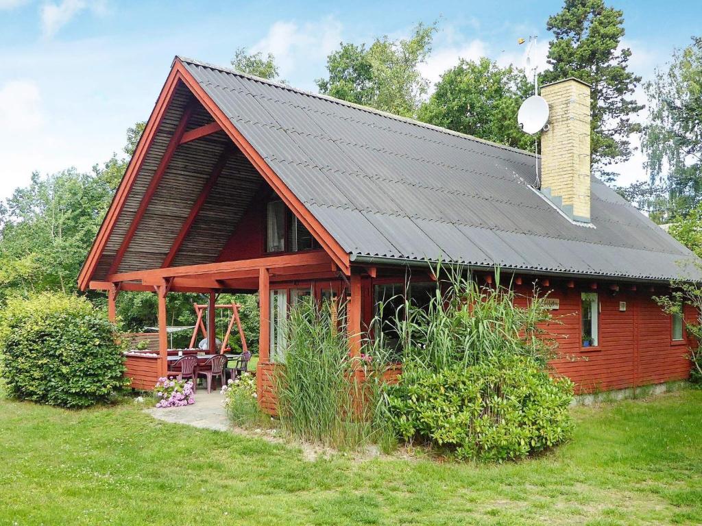 格莱斯堡Holiday home Glesborg XL的黑色屋顶红色小屋