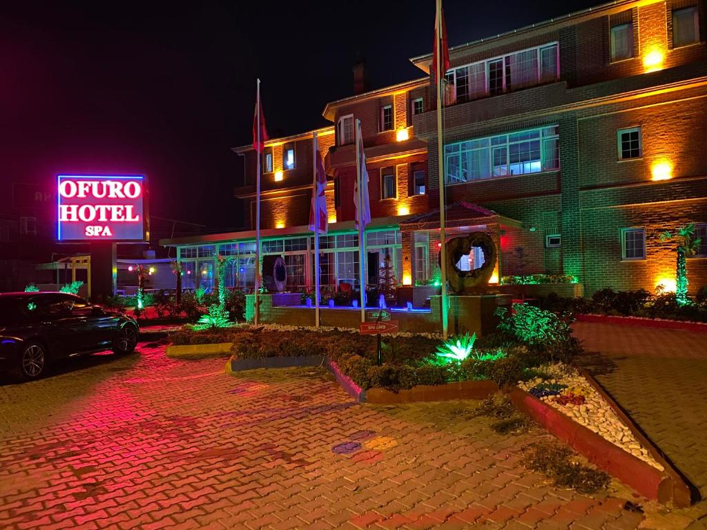 伊兹密尔OFURO WORLD HOTEL SPA的前面有 ⁇ 虹灯标志的建筑