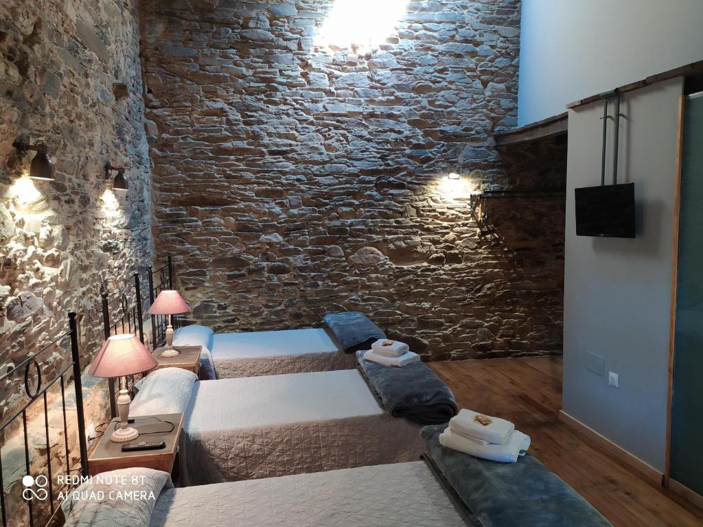 特里亚卡斯特拉Albergue Atrio的一间卧室设有两张床和砖墙