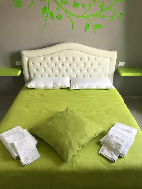 卡塞勒托瑞尼斯Rosa verde的一张绿色的床,上面有两条白色毛巾