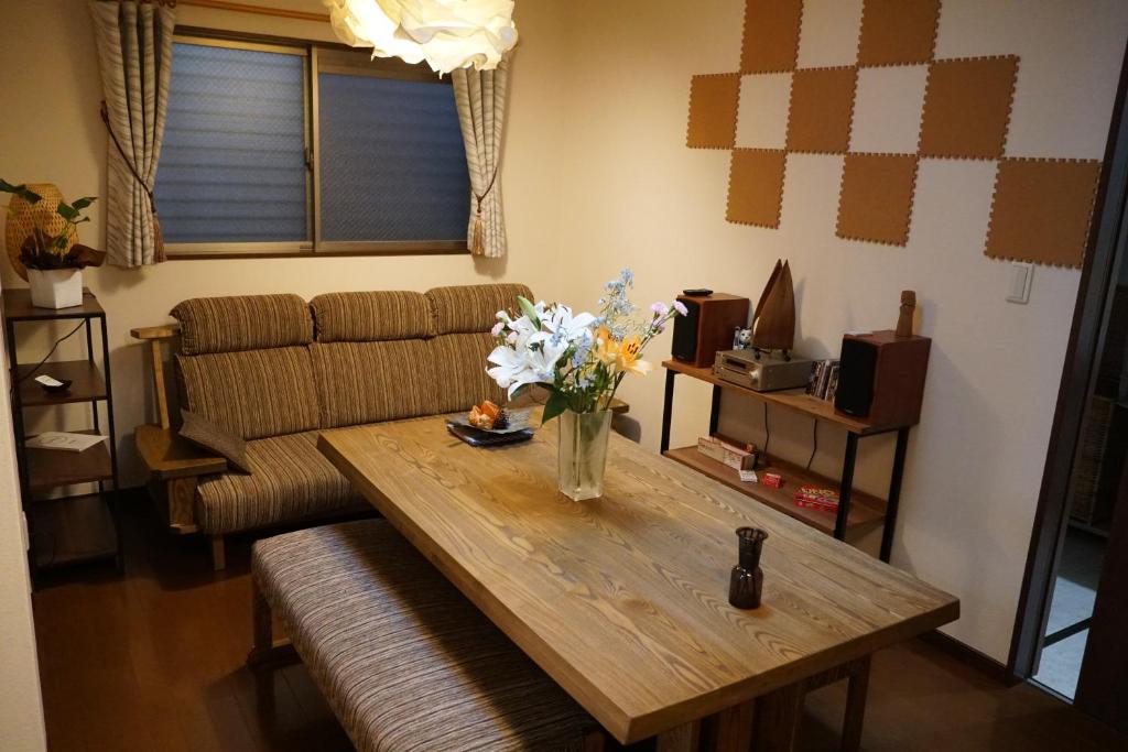 大阪Auberge du Tanuki Noir Maison d'Hôtes的客厅配有桌子和沙发