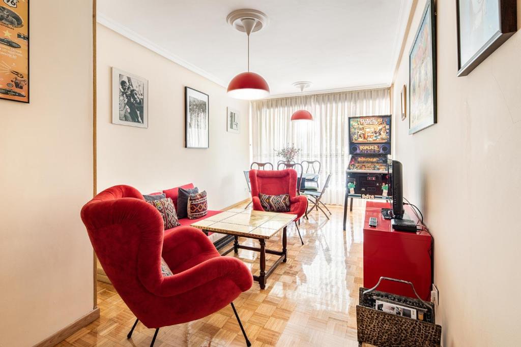奥维多Magnifico apartamento en el centro de Oviedo的客厅配有红色椅子和桌子