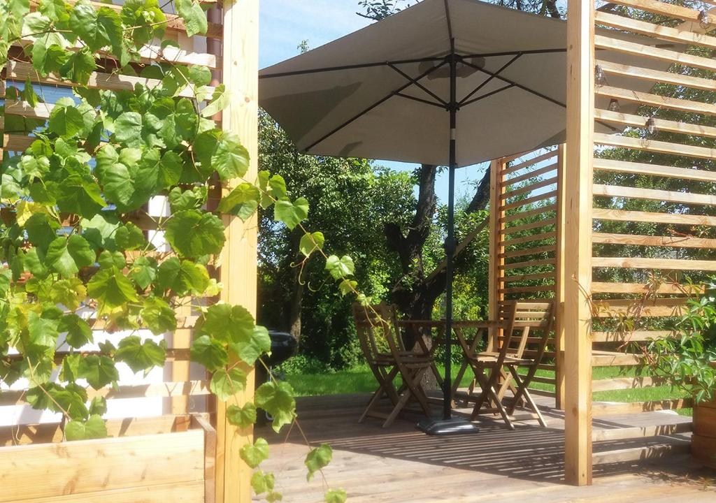 扎托尔Apartamenty-Obok的庭院配有遮阳伞和桌椅。