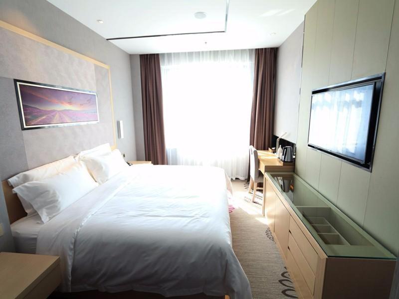 吉林Lavande Hotel Jilin Songjiang Road Jiangwan Bridge Branch的酒店客房,配有床和电视