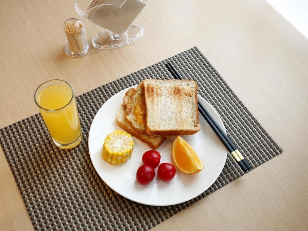九江Lavande Hotel Jiujiang Jiujiang College的一块烤面包和水果,加上一杯橙汁