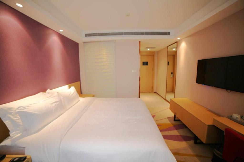 哈尔滨Lavande Hotel (Harbin Ice and Snow World University of Commerce Branch)的卧室配有白色的床和平面电视。