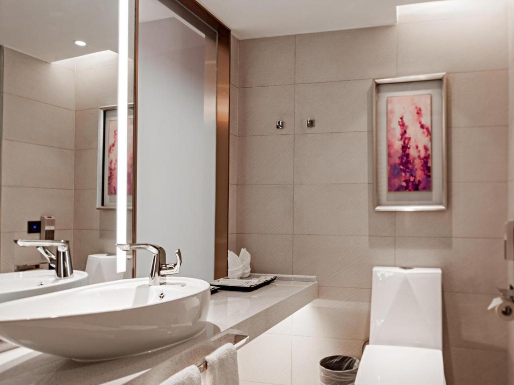 长沙Lavande Hotel Changsha Avenue Metro Station的白色的浴室设有水槽和镜子
