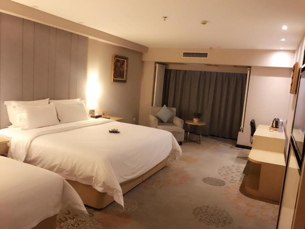 银川Lavande Hotel Yinchuan Wanda International Convention and Exhibition Center的酒店客房,配有两张床和椅子